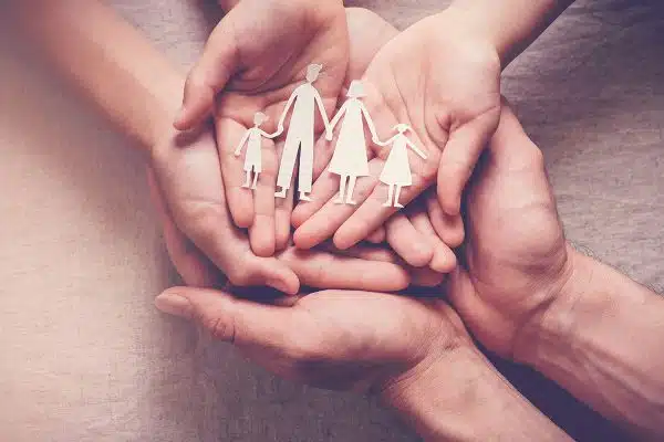 caring family holding paper cutouts