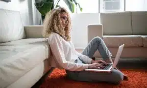 Teenager sitting on floor using laptop