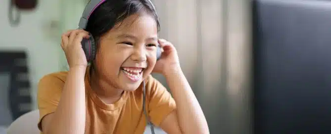 Happy girl speaking with a therapist on computer wearing headphones