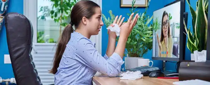 Teenager crying with tissues on a virtual meeting with counselor